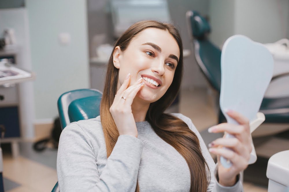 Woman checking her perfect smile at the dentist - Teeth Straightening in Georgetown, TX