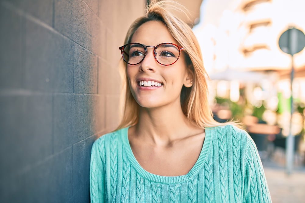 Portrait of a woman leaning on a wall - Dental Bridge in Georgetown, TX