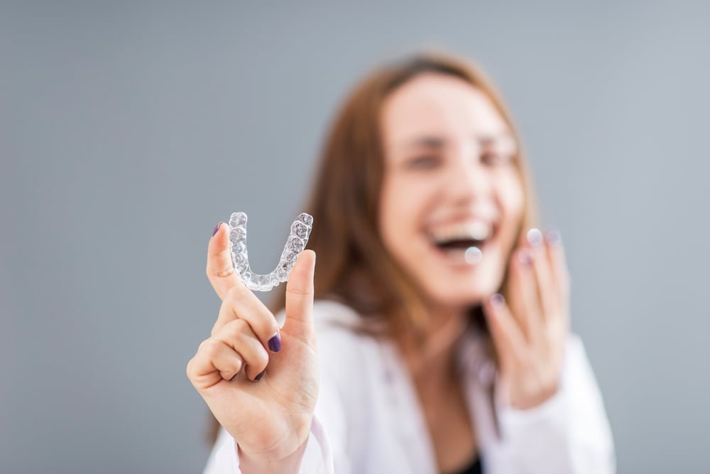 Woman holding an Invisalign - Invisalign Treatment in Georgetown, TX Woman holding a dental aligner